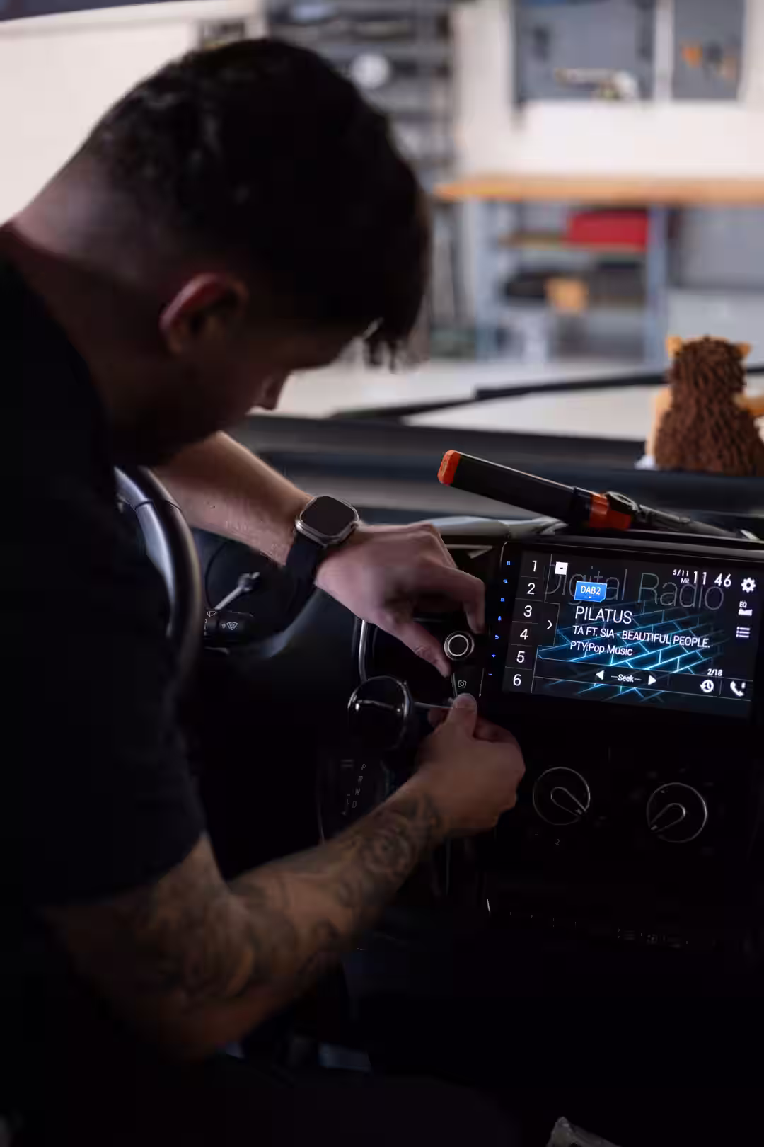 Installateur montiert einen Drehregler an einem Autoradio